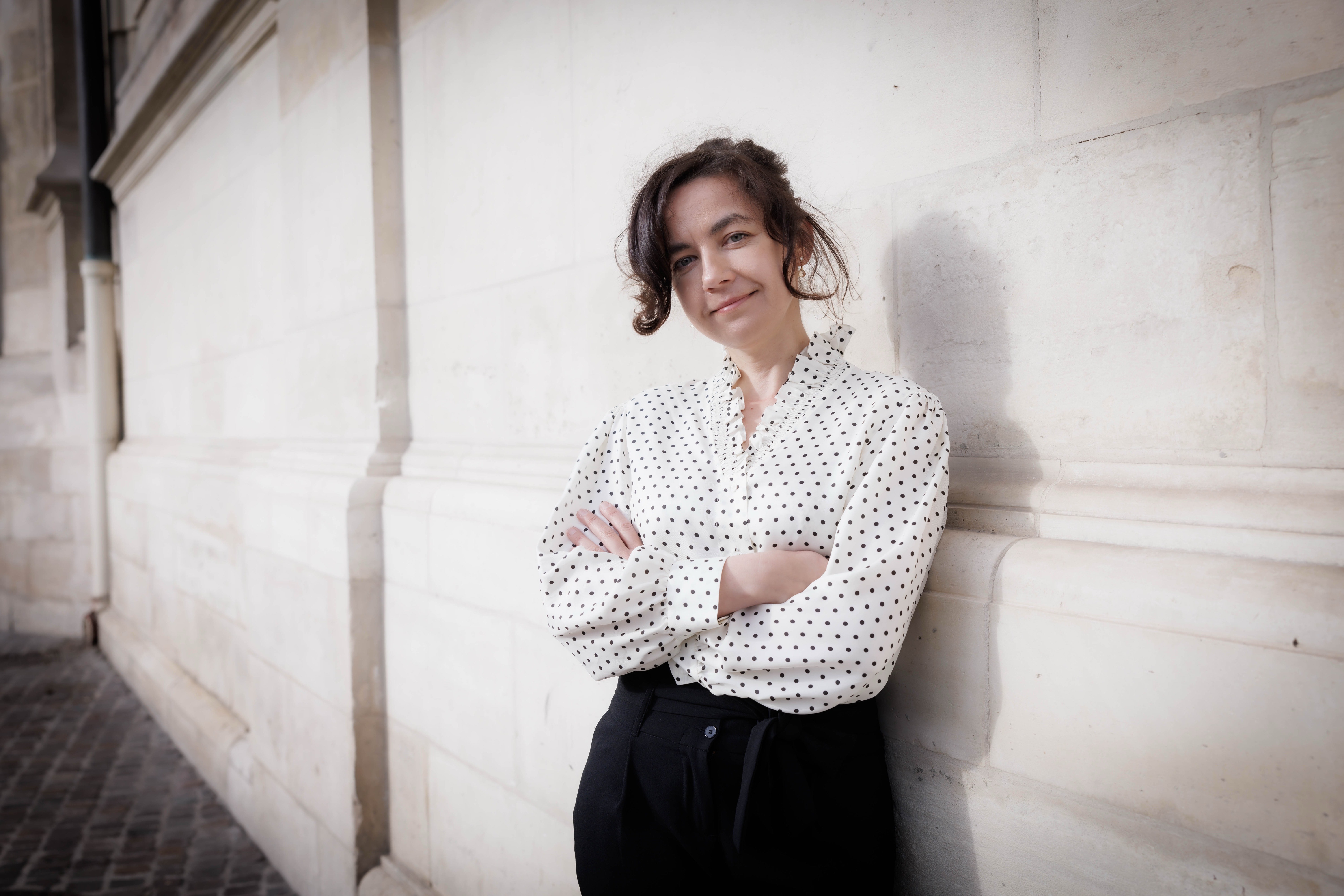 Woman leaning against a stone wall