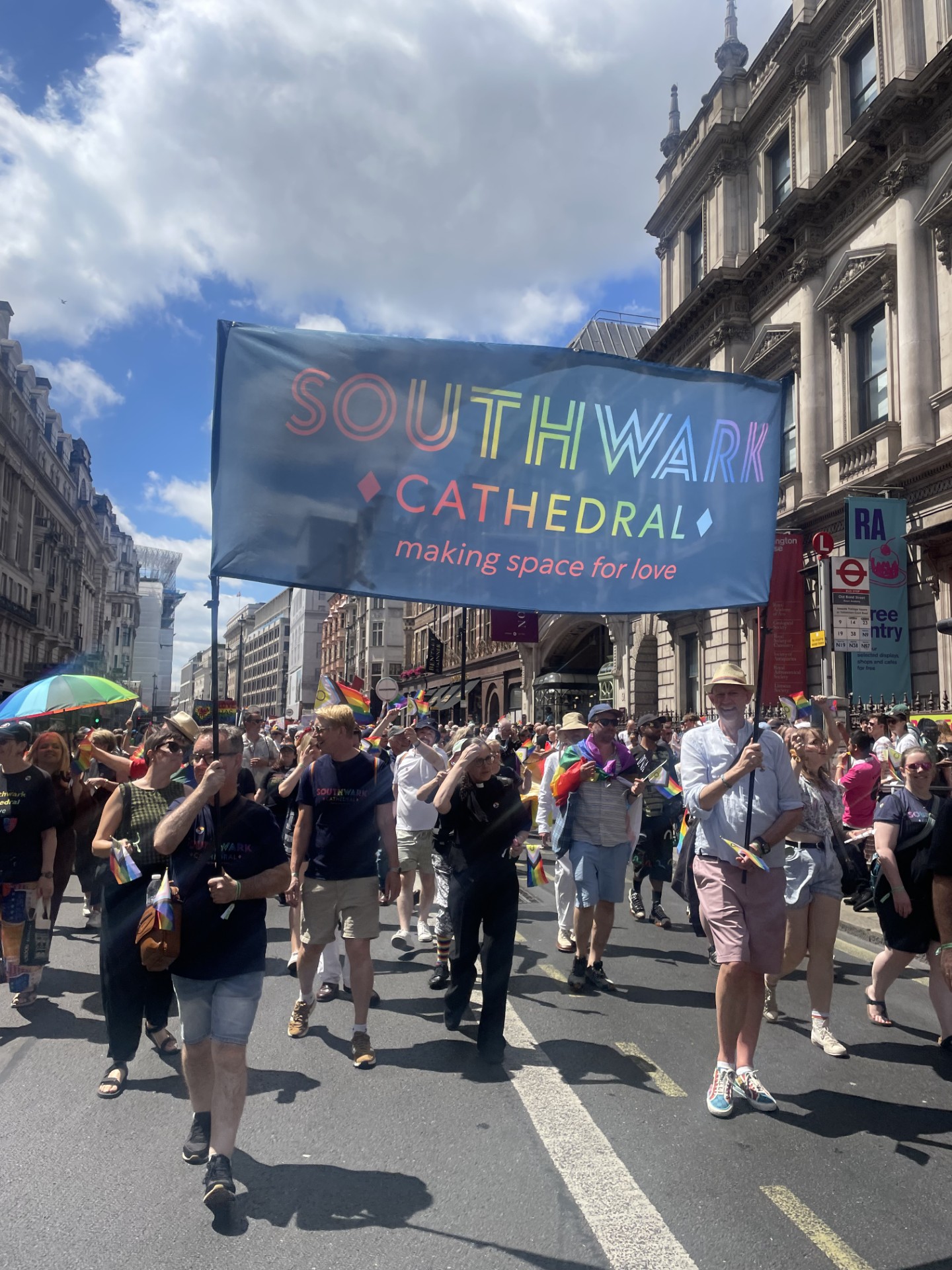 A group of people carrying a pride banner in a pride march