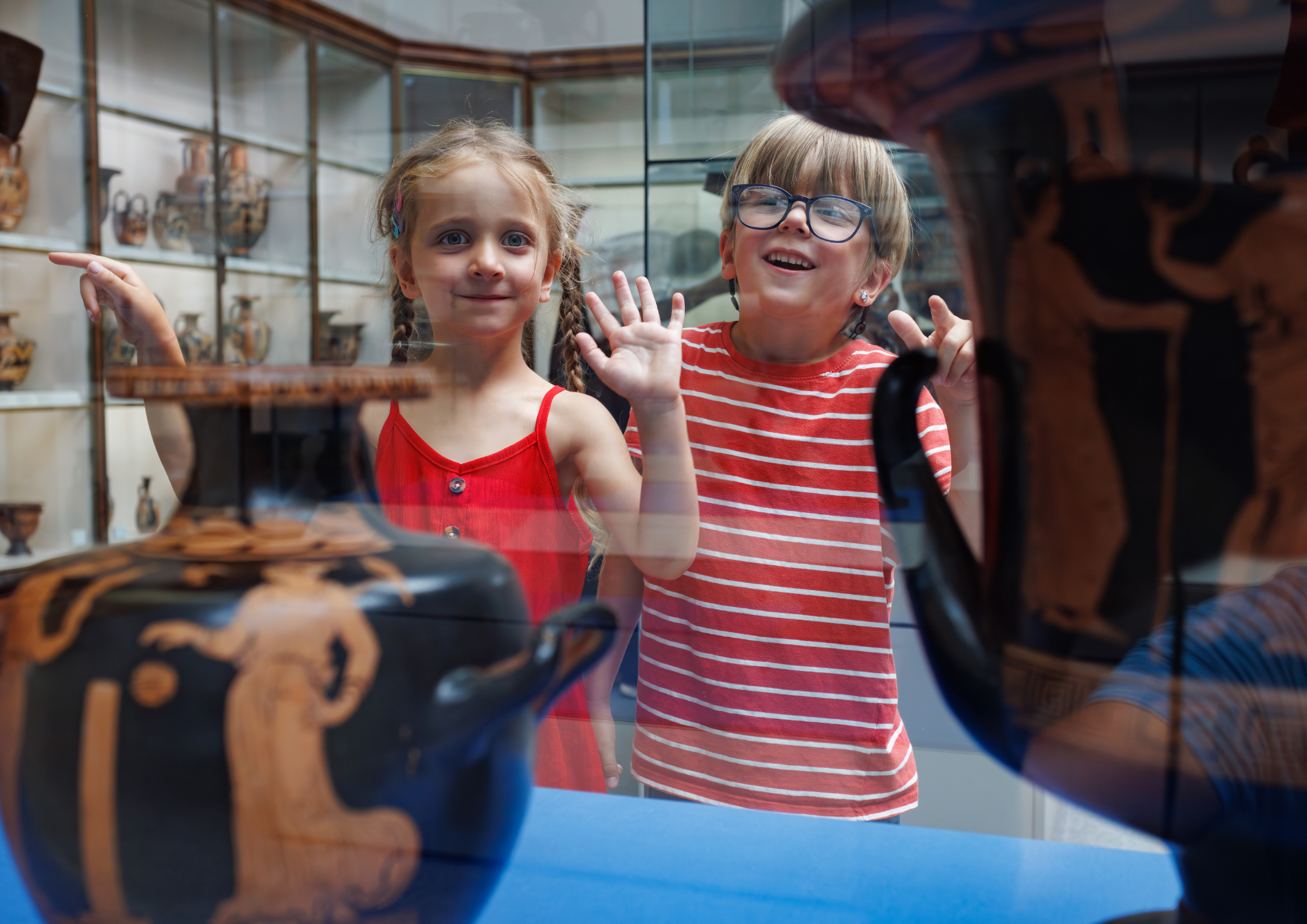 Two children looking at objects in a museum