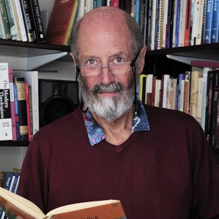 Adrian Theatcher in a library holding a book